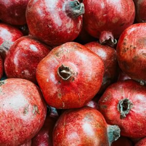 A vibrant collection of fresh red pomegranates showcasing their natural texture and color.